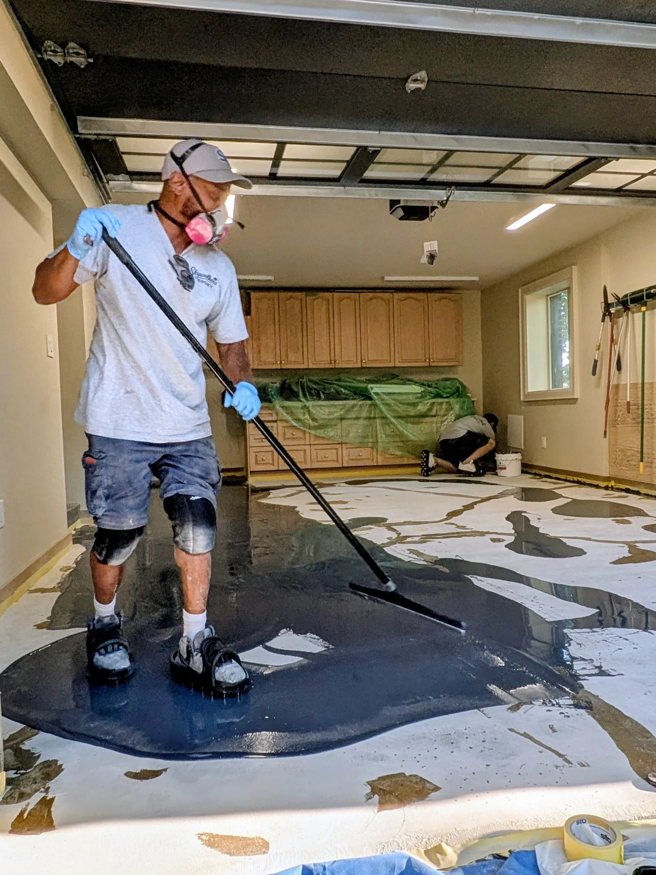 Installer applying coating to the prepared garage floor